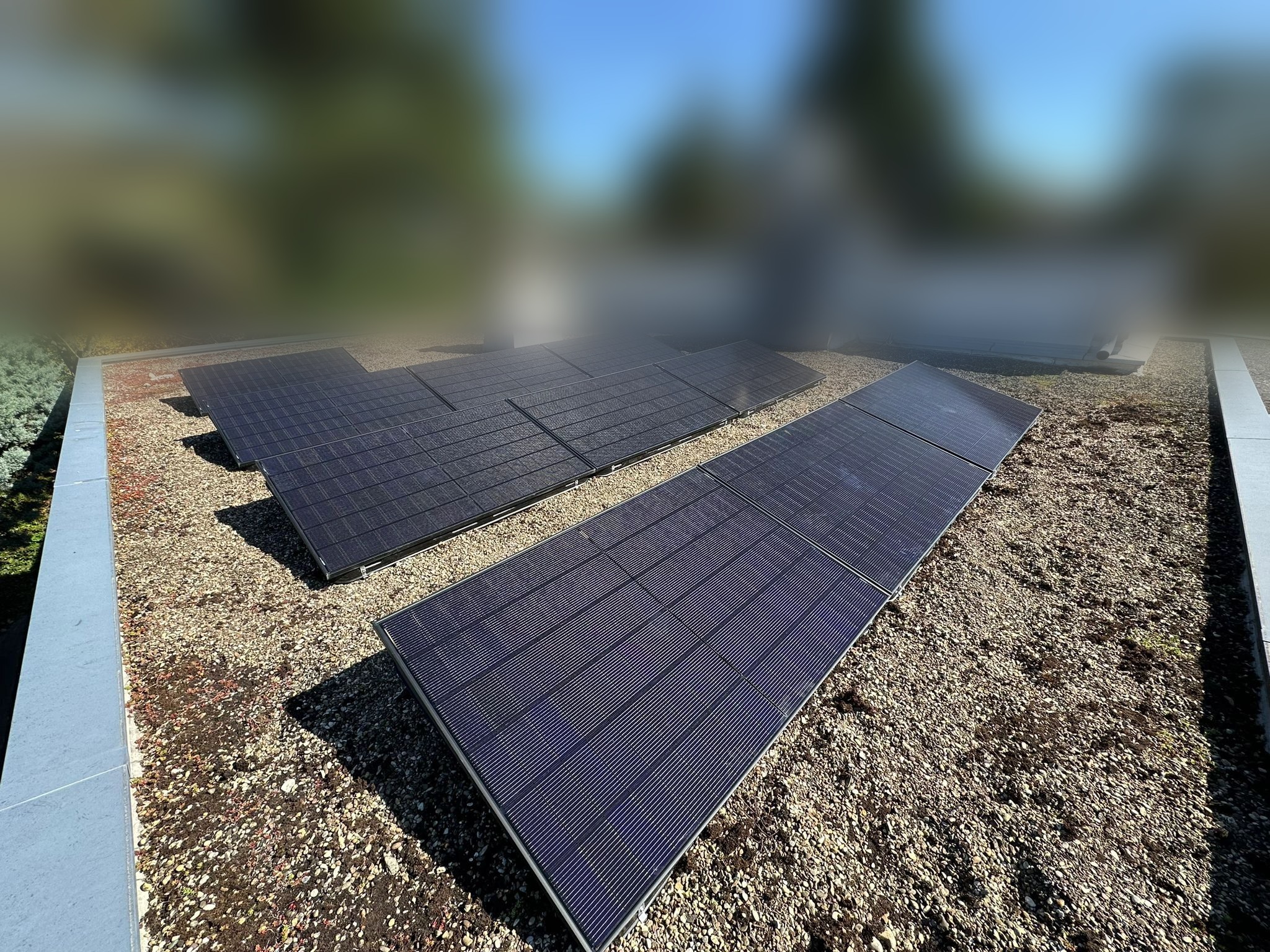 Panneaux photovoltaïques installés sur une toiture plate gravillonnée d'une maison individuelle