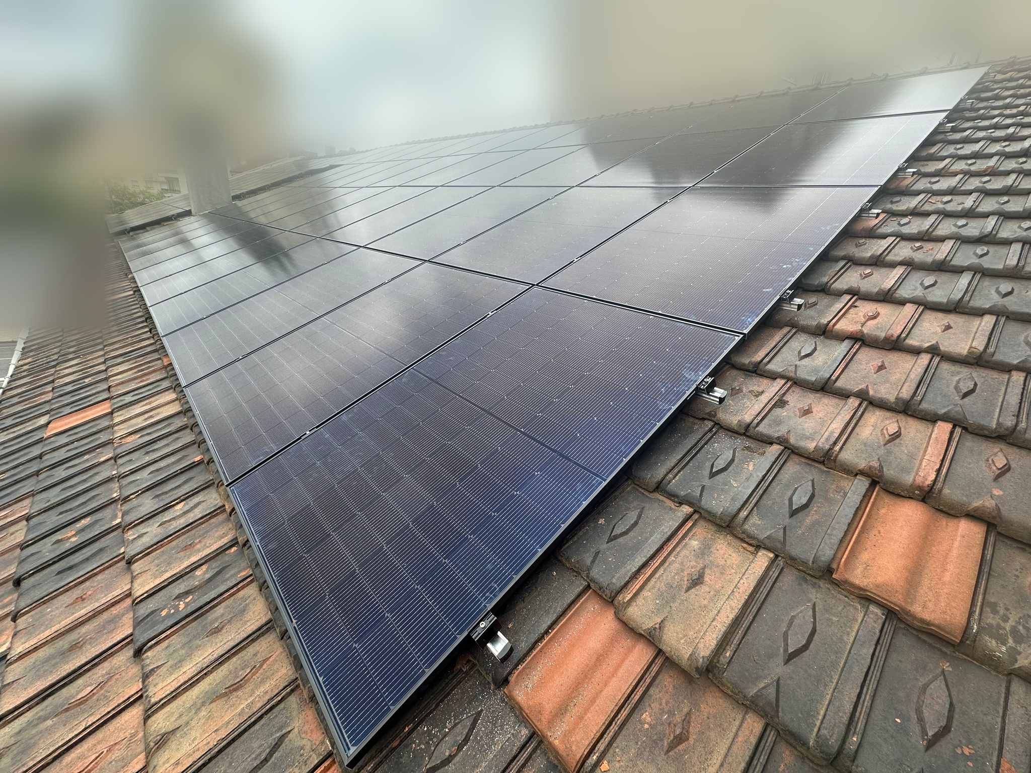 Panneaux photovoltaïques posés sur une toiture en tuiles d'un bâtiment industriel